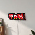 Unlit Toys For Tots Train LED lightbox mounted on a wall in daylight