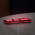 Toys For Tots Train LED lightbox lying flat on a desk with red glow