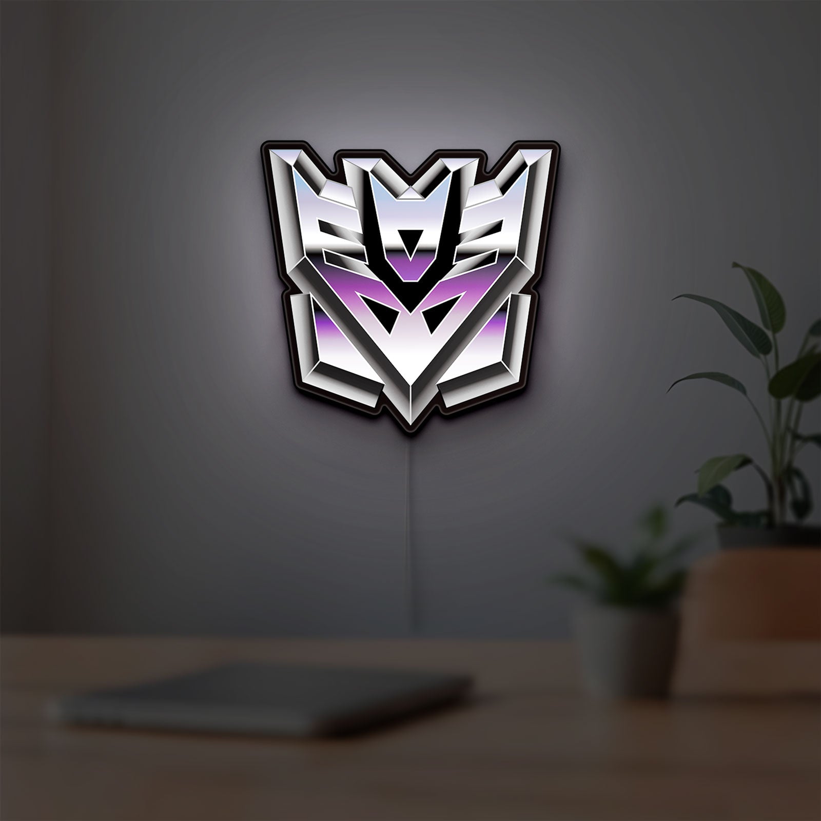Decepticon LED lightbox hanging on a room wall with soft purple light