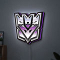 Decepticon LED lightbox hanging on a wall with purple glow