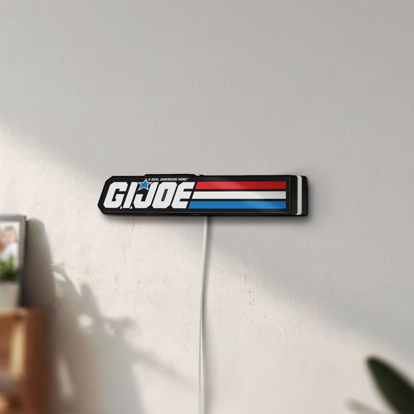 Unlit G.I. Joe LED lightbox mounted on a wall in daylight