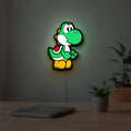 Yoshi LED lightbox hanging on a room wall with soft green light