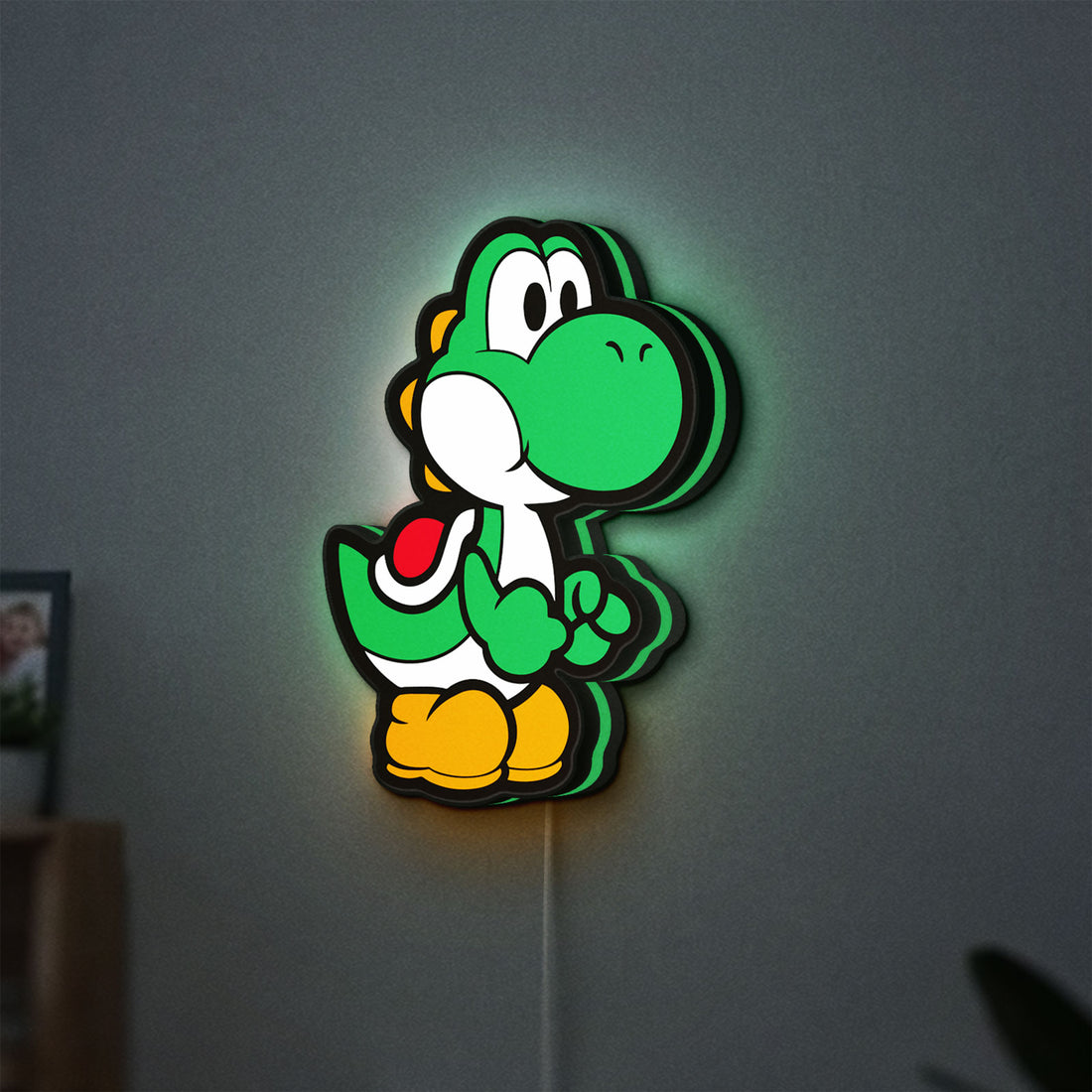 Yoshi LED lightbox hanging on a wall with green glow