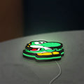 Yoshi LED lightbox lying flat on a desk with green glow