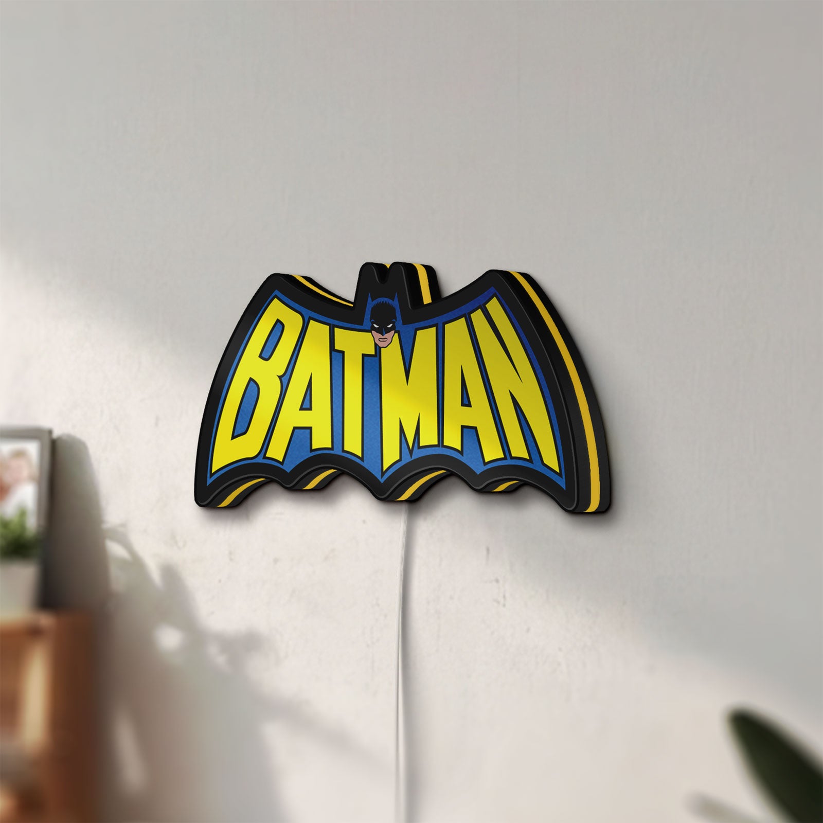 Unlit Batman LED lightbox mounted on a wall in daylight