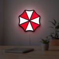 Umbrella Corps LED lightbox hanging on a room wall with soft red light