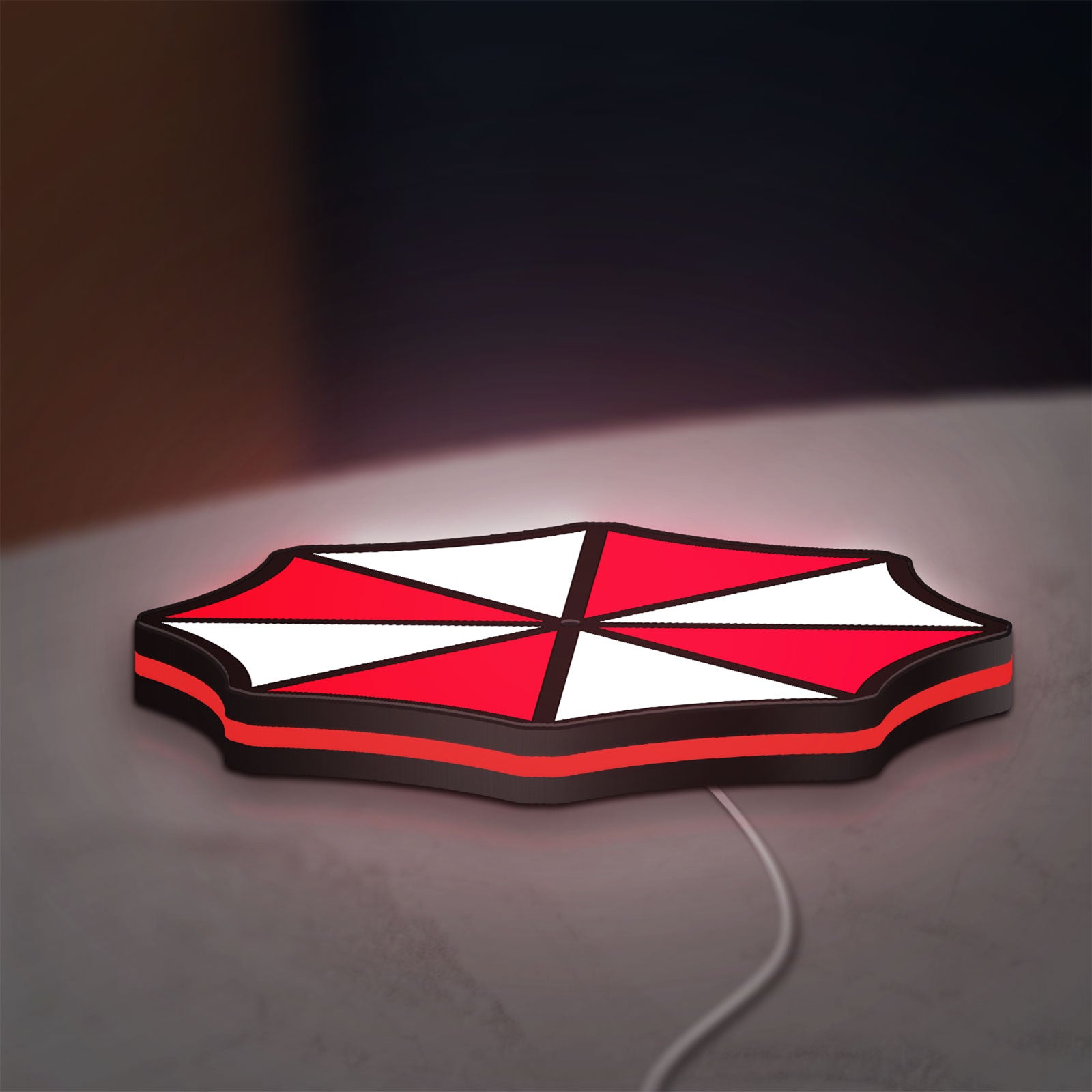 Umbrella Corps LED lightbox lying flat on a desk with red glow