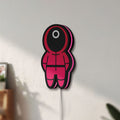Unlit Squid Game LED lightbox mounted on a wall in daylight