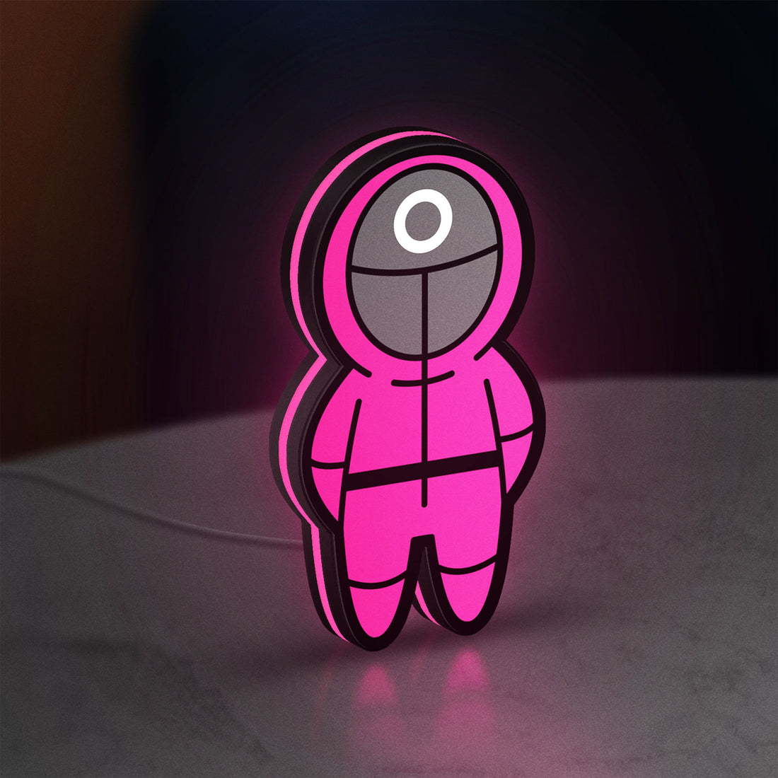 Squid Game LED lightbox hanging on a wall with pink glow