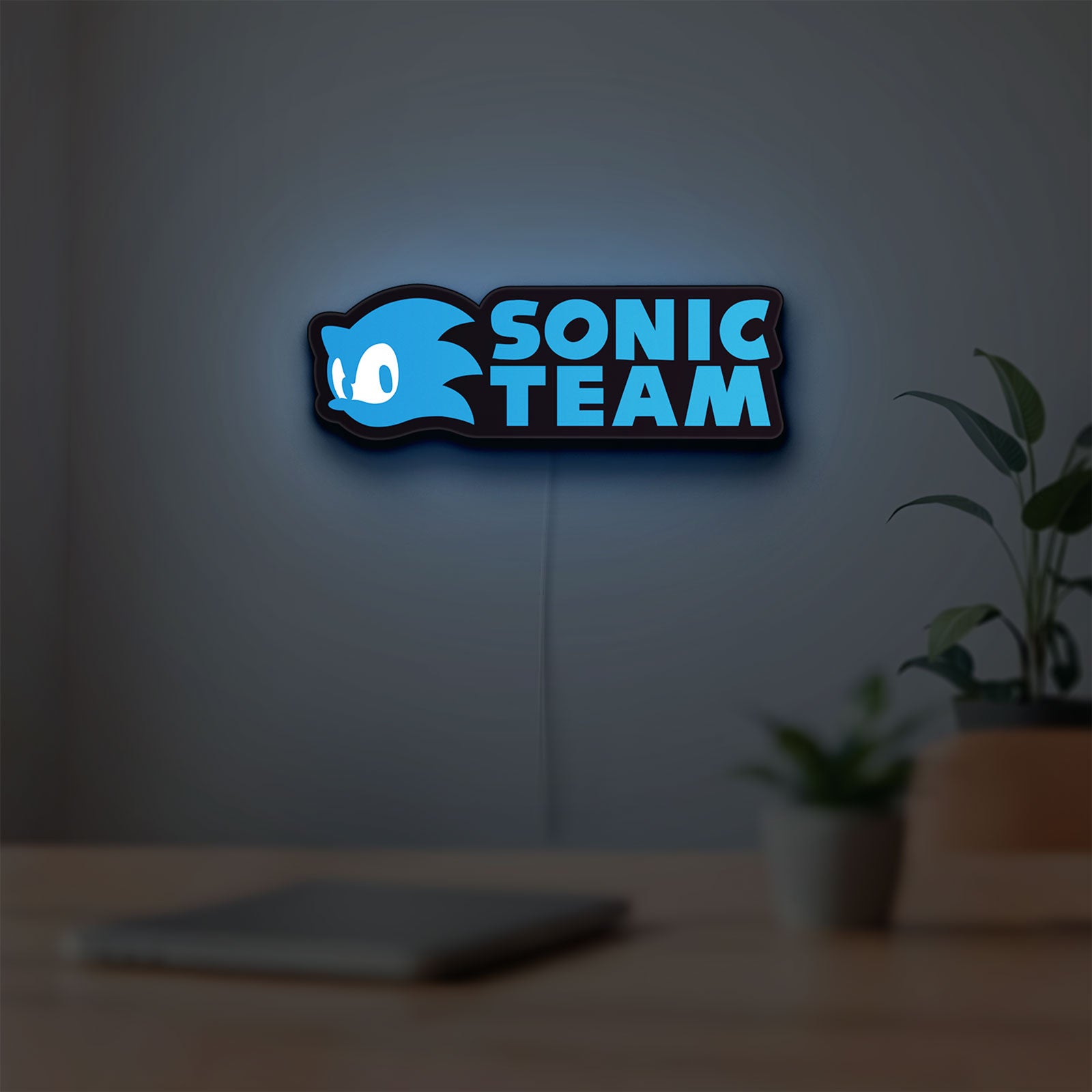Sonic Team LED lightbox hanging on a room wall with soft blue light