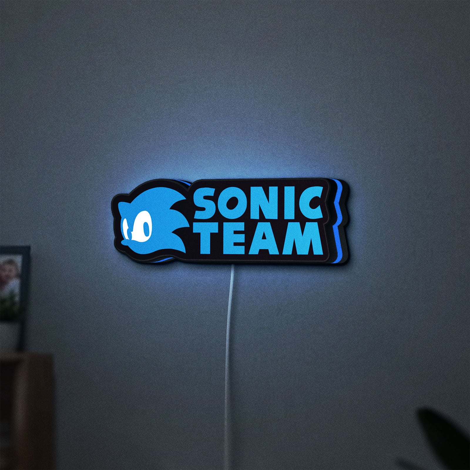 Sonic Team LED lightbox hanging on a wall with blue glow