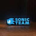 Front view of Sonic Team LED lightbox sign glowing on a wooden desk