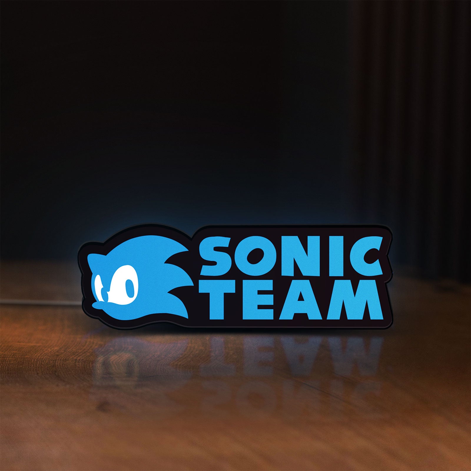 Front view of Sonic Team LED lightbox sign glowing on a wooden desk