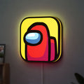 Among Us LED lightbox hanging on a wall with yellow glow