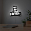 Fortnite LED lightbox hanging on a room wall with soft white light