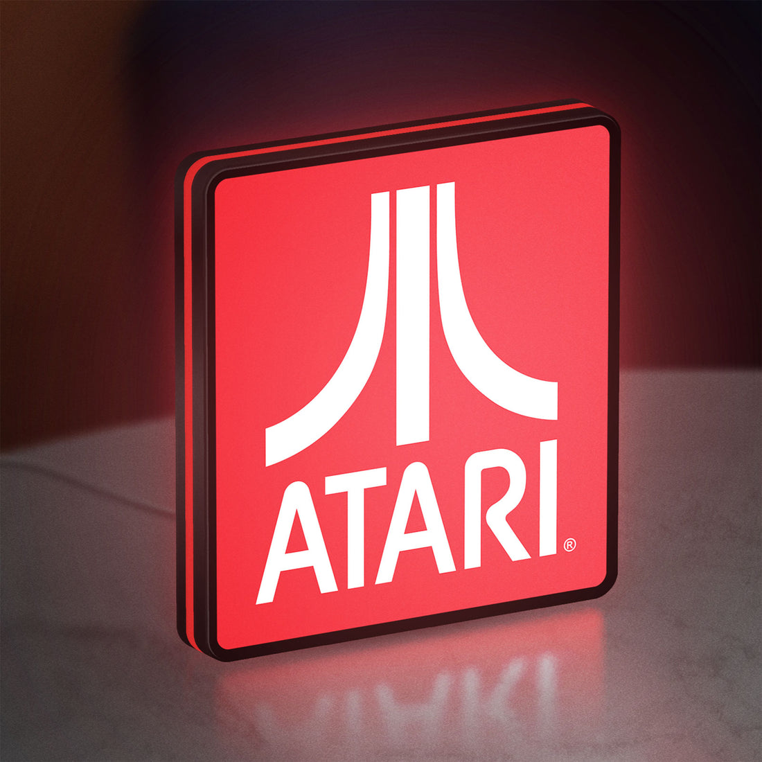 Atari LED lightbox hanging on a wall with red glow