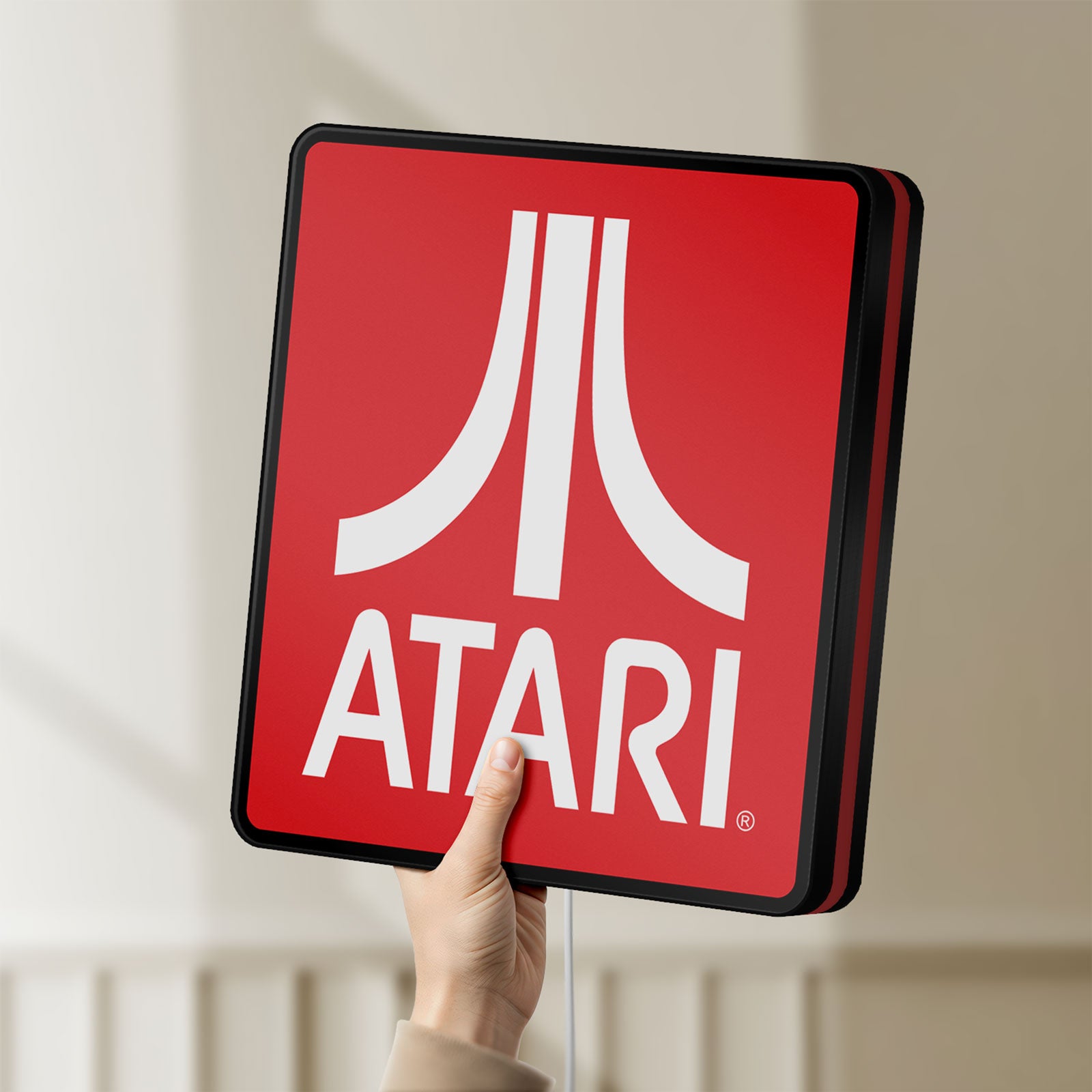 Unlit Atari LED lightbox held by hand to show size and details