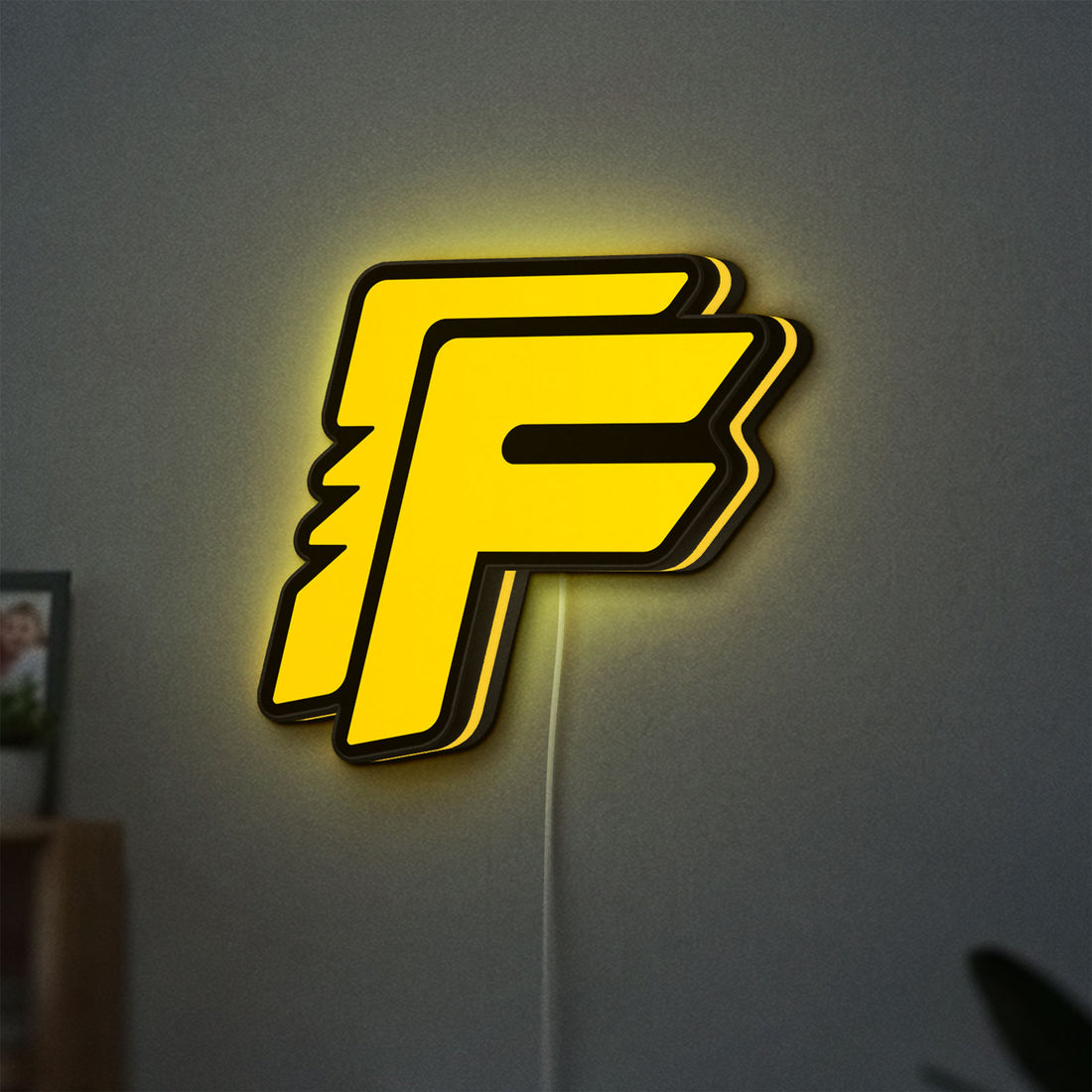 Free Fire LED lightbox hanging on a wall with yellow glow