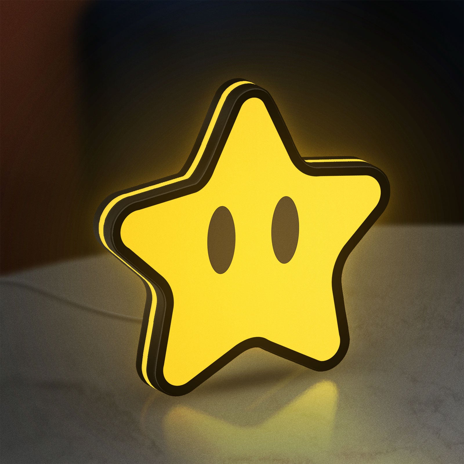 Super Mario Star LED lightbox standing on a desk from an angled side view with yellow glow