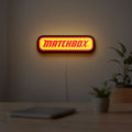 Matchbox LED lightbox hanging on a room wall with soft yellow light
