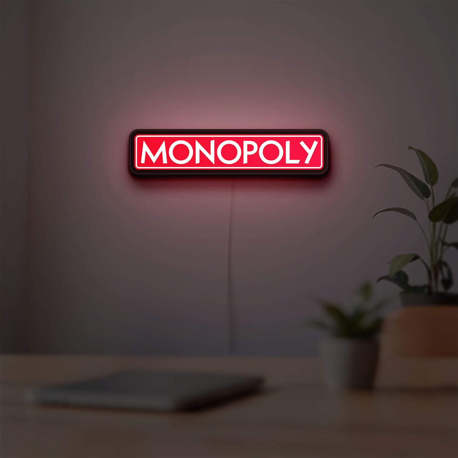 Monopoly Money Bag LED lightbox hanging on a room wall with soft red light