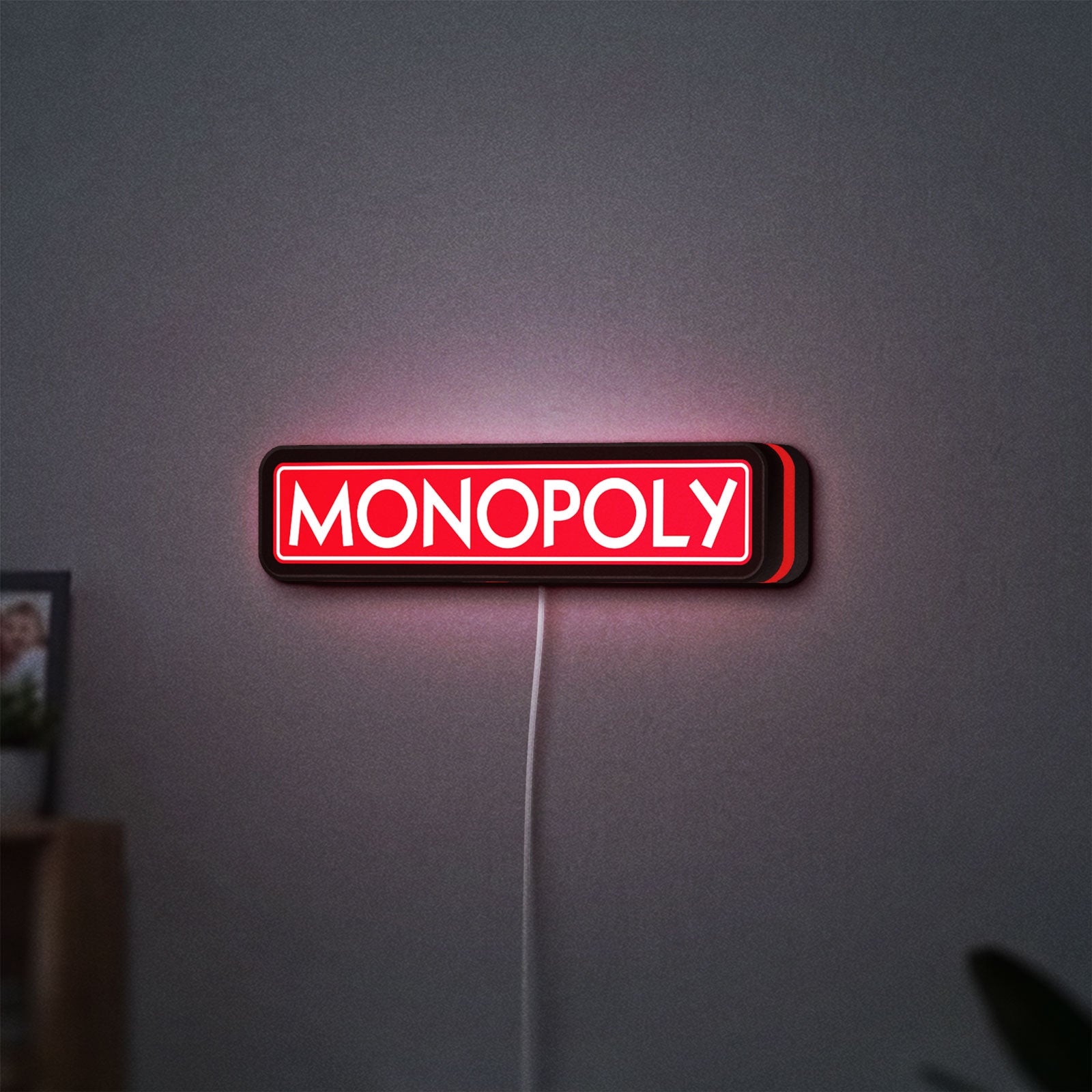 Monopoly Money Bag LED lightbox hanging on a wall with red glow