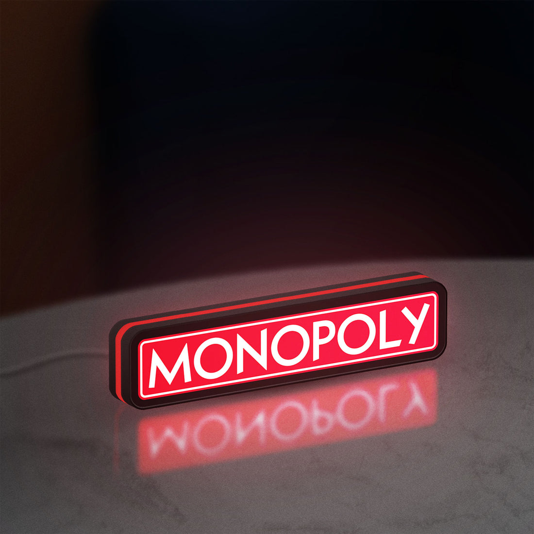 Monopoly Money Bag LED lightbox hanging on a wall with red glow