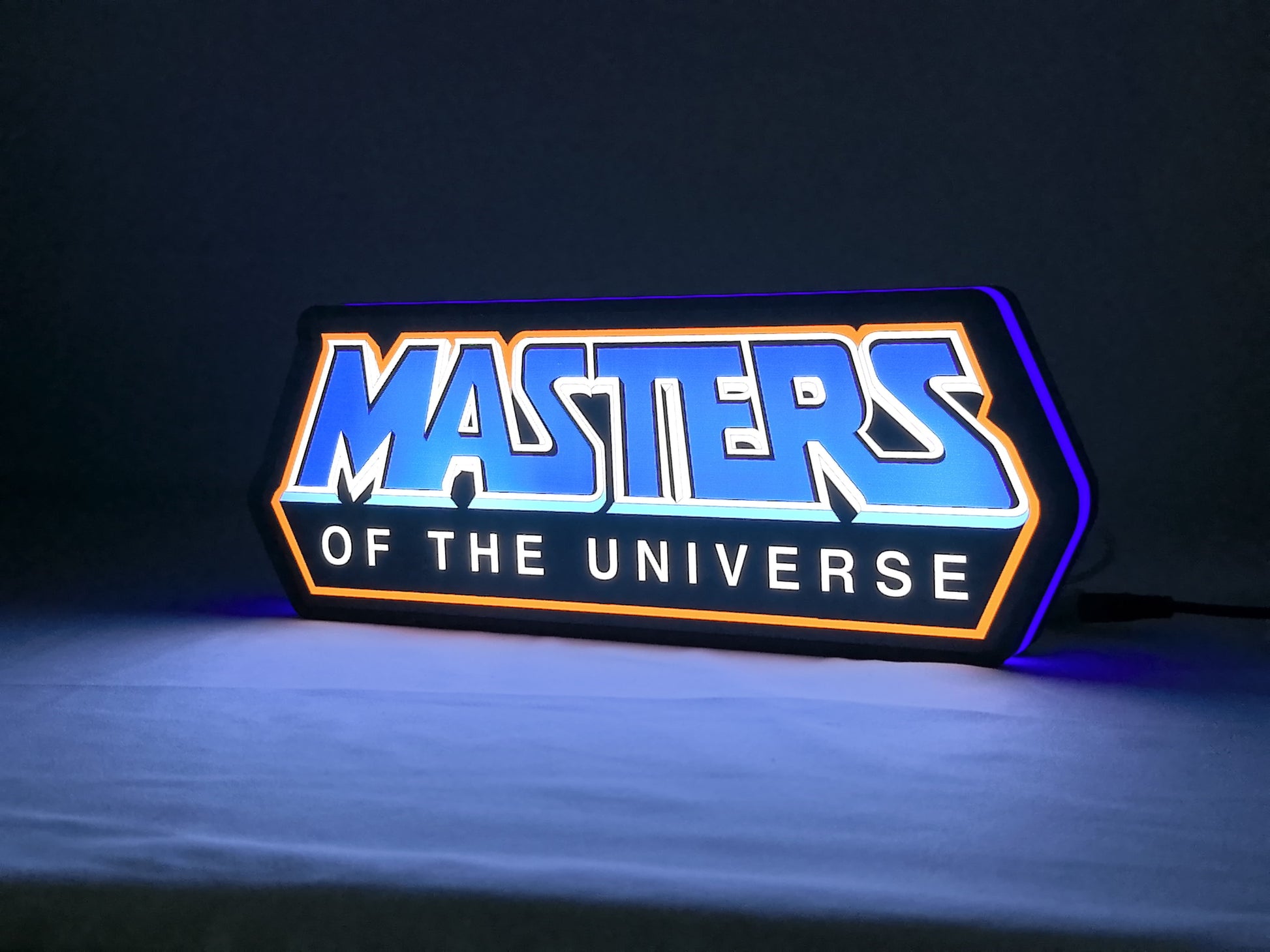 Illuminated angled view standing of Masters Of The Universe Illuminated Sign in 30cm, unique wall art for desk and room decor