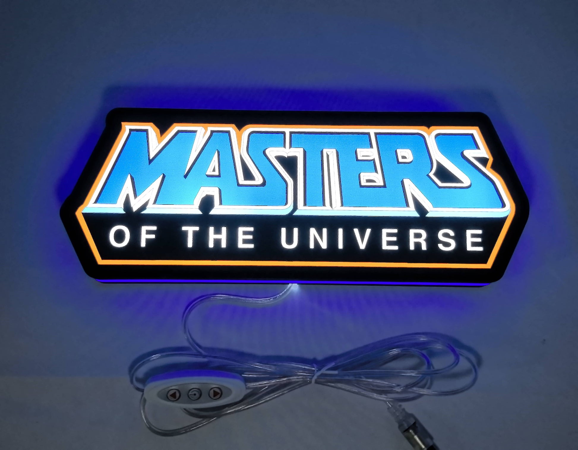 Illuminated flat lay front view of Masters Of The Universe 3D LED Sign in 30cm, unique wall art for desk and room decor