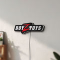 Unlit Boyztoys Racing LED lightbox mounted on a wall in daylight