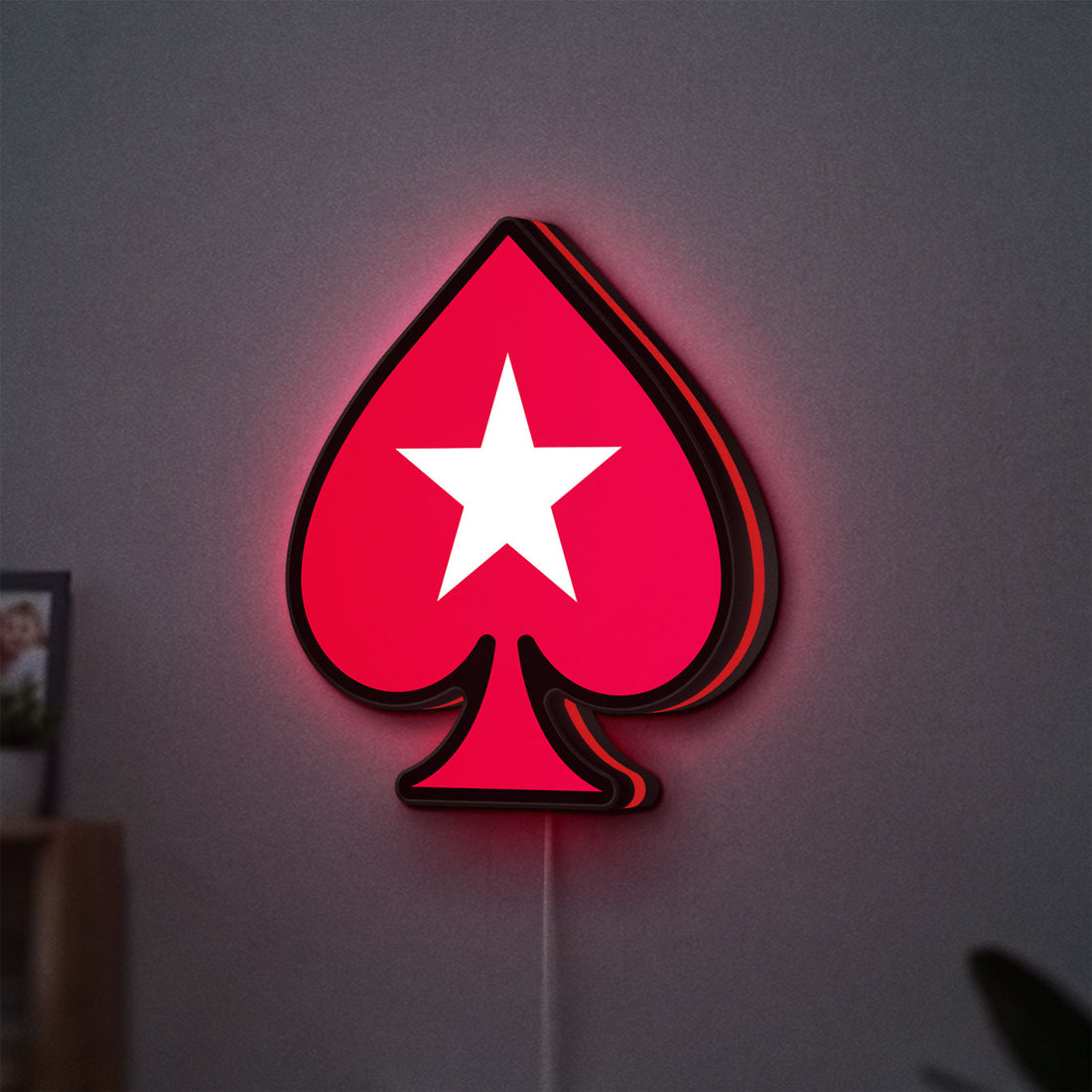 PokerStars Ace LED lightbox hanging on a wall with red glow