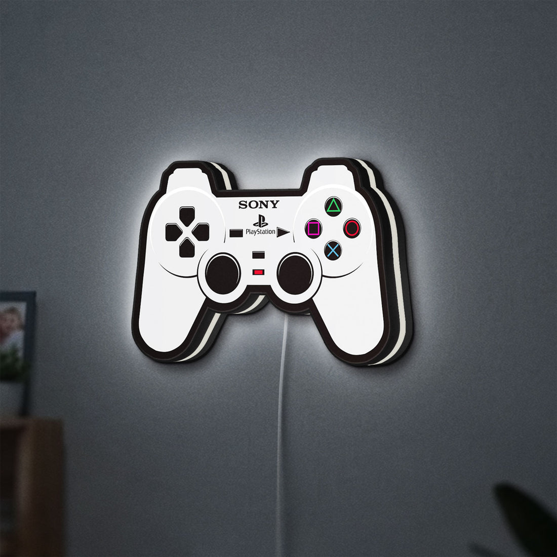 Sony PlayStation Pad LED lightbox hanging on a wall with white glow