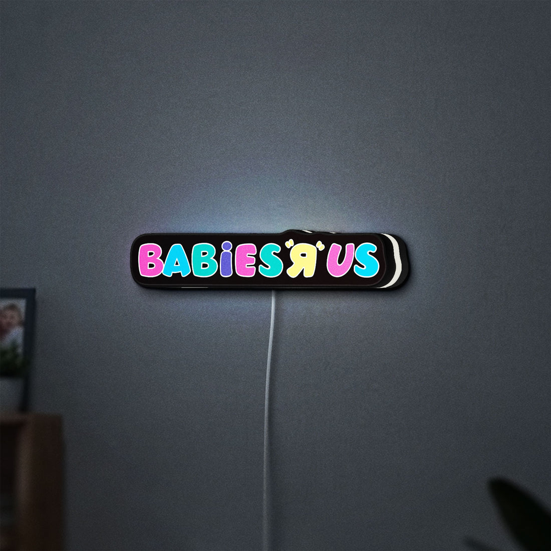 Babies R Us LED lightbox hanging on a wall with white glow
