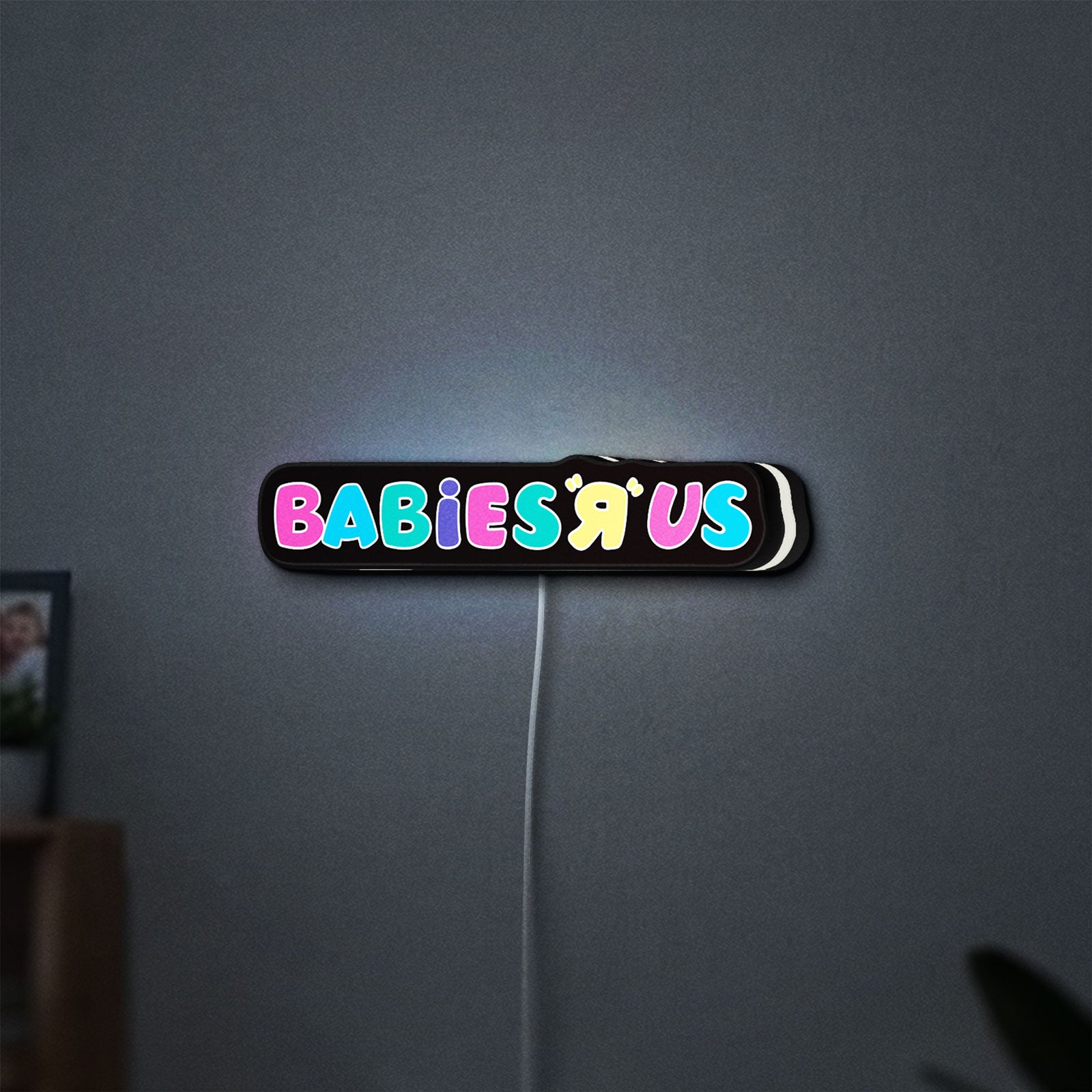 Babies R Us LED lightbox hanging on a wall with white glow