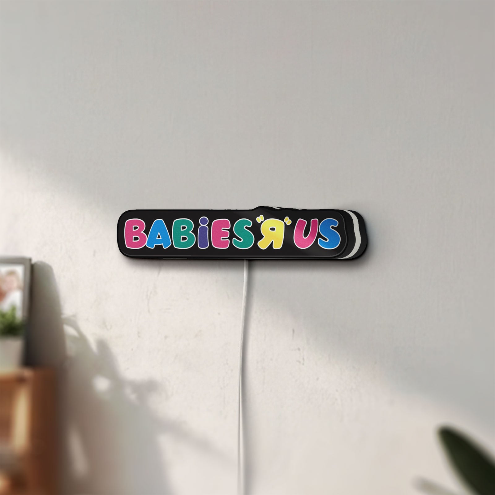 Unlit Babies R Us LED lightbox mounted on a wall in daylight