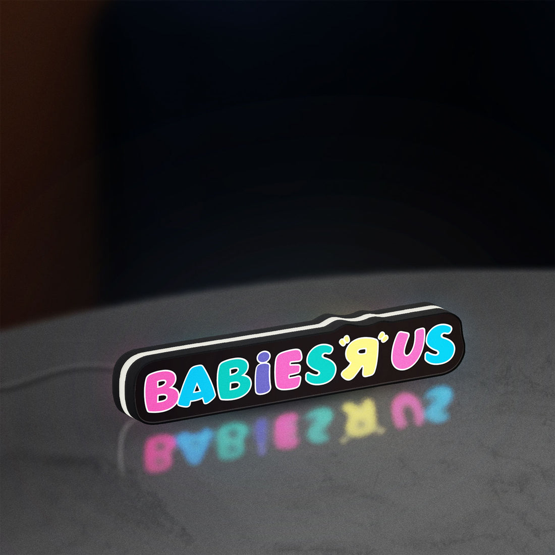 Babies R Us LED lightbox hanging on a wall with white glow