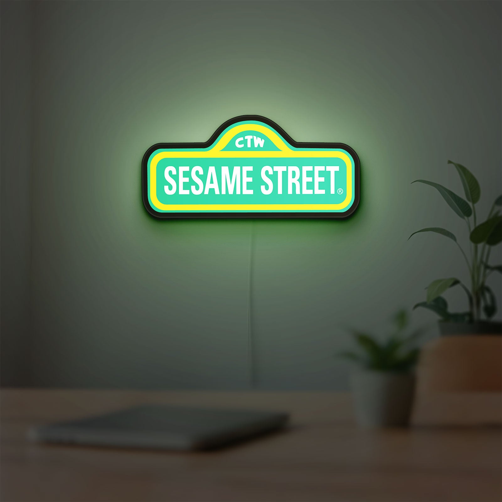 Sesame Street LED lightbox hanging on a room wall with soft green light