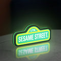 Sesame Street LED lightbox standing on a desk from an angled side view with green glow