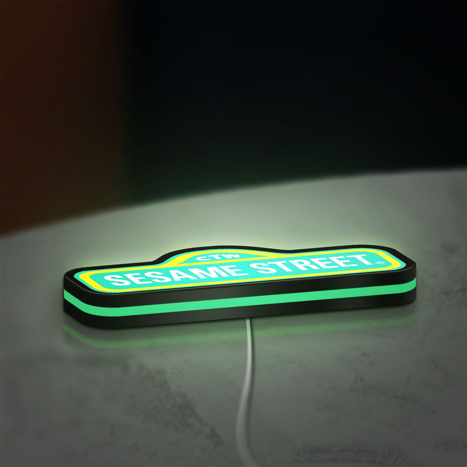 Sesame Street LED lightbox lying flat on a desk with green glow