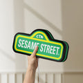 Unlit Sesame Street LED lightbox held by hand to show size and details