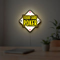Four Card Poker LED lightbox hanging on a room wall with soft yellow light