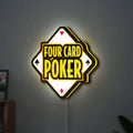 Four Card Poker LED lightbox hanging on a wall with yellow glow