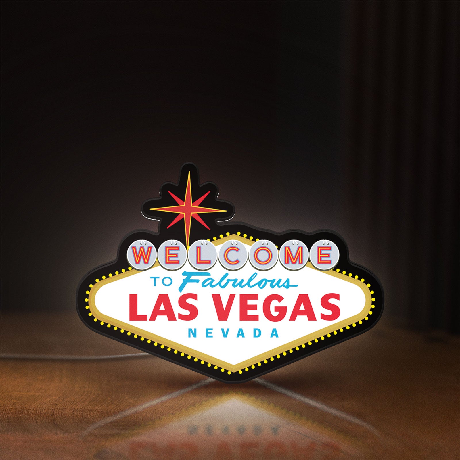 Front view of Las Vegas Nevada LED lightbox sign glowing on a wooden desk