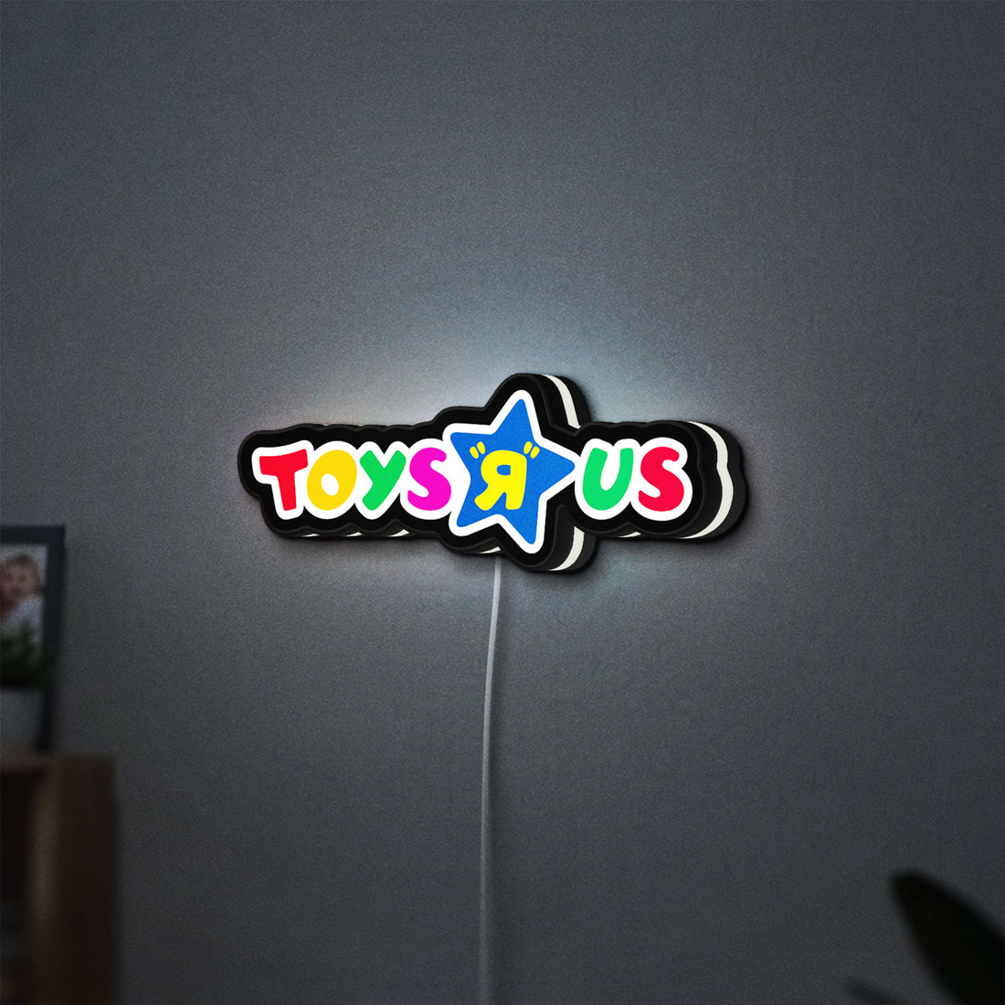 Toys R Us LED lightbox hanging on a wall with white glow