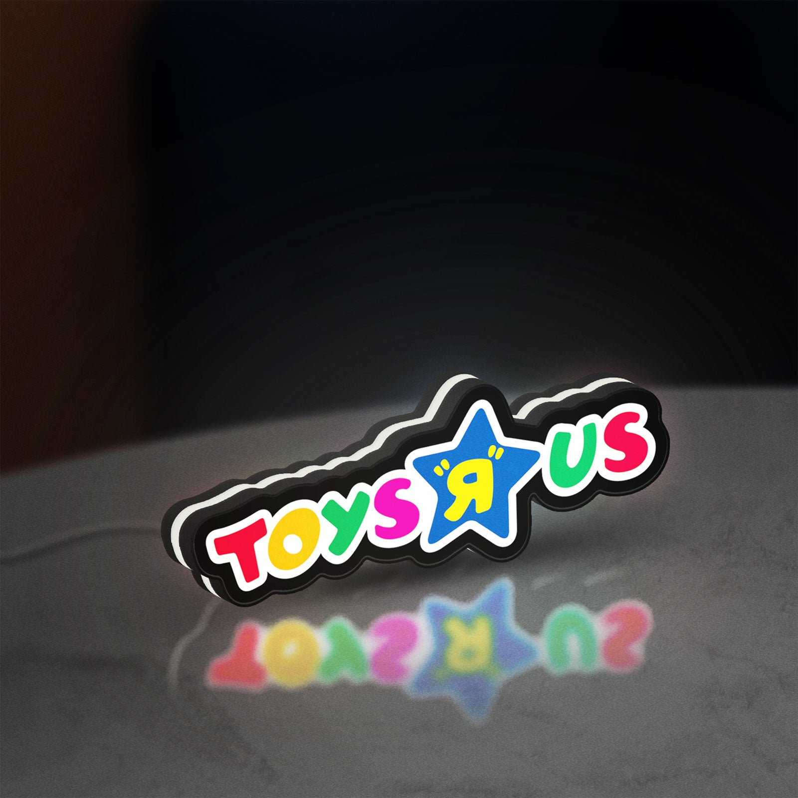 Toys R Us LED lightbox standing on a desk from an angled side view with white glow