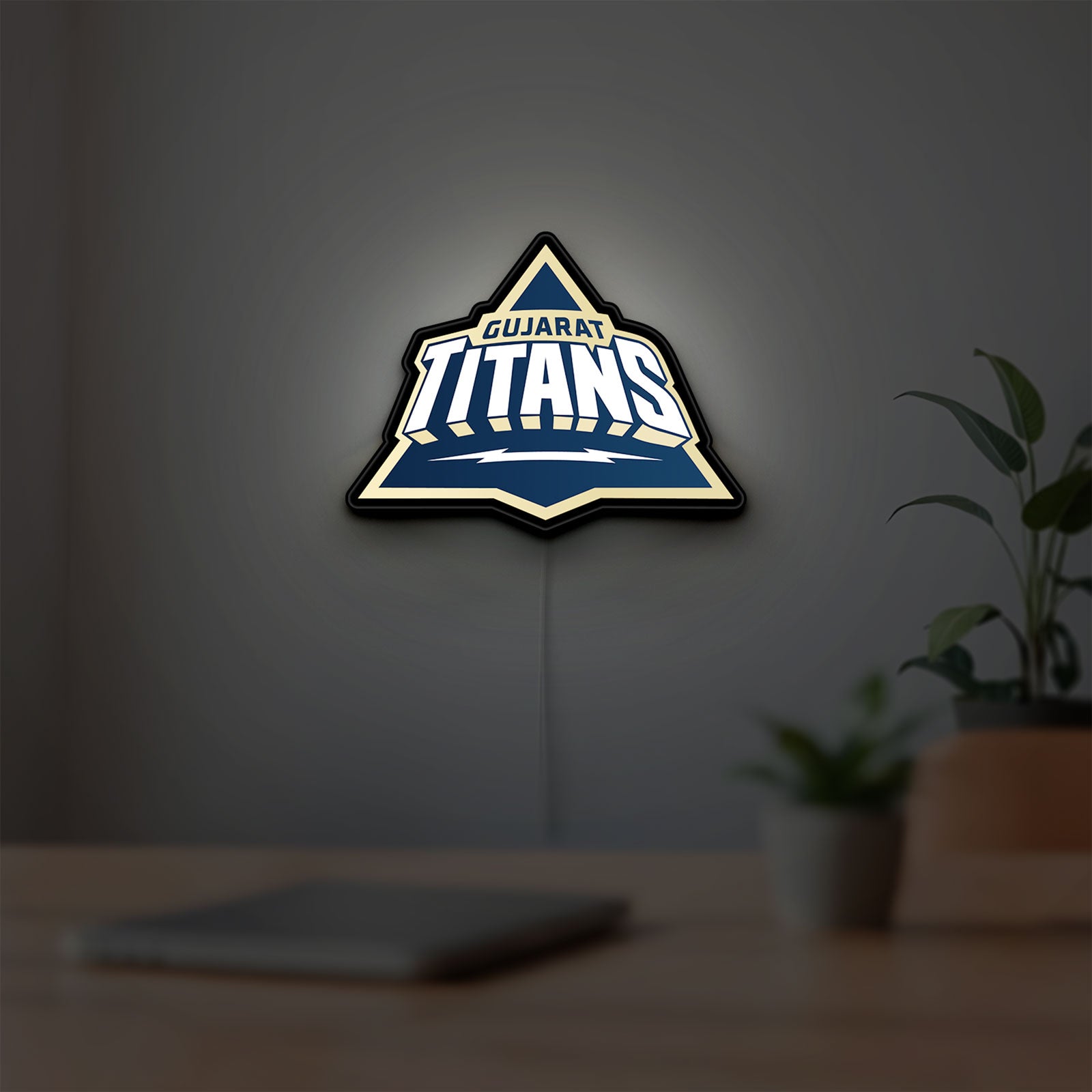 Gujarat Titans LED lightbox hanging on a room wall with soft yellow light