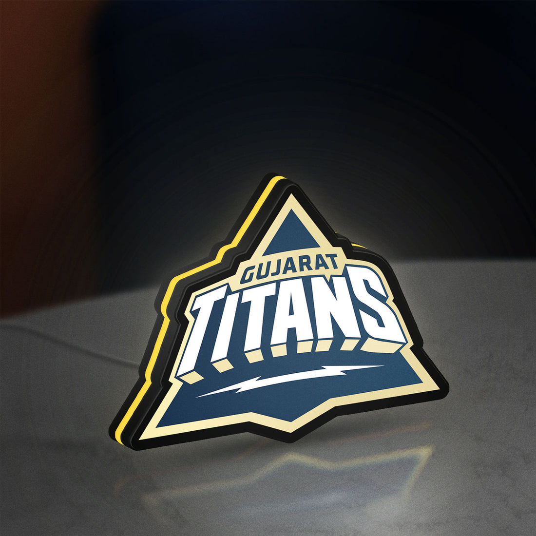 Gujarat Titans LED lightbox hanging on a wall with yellow glow