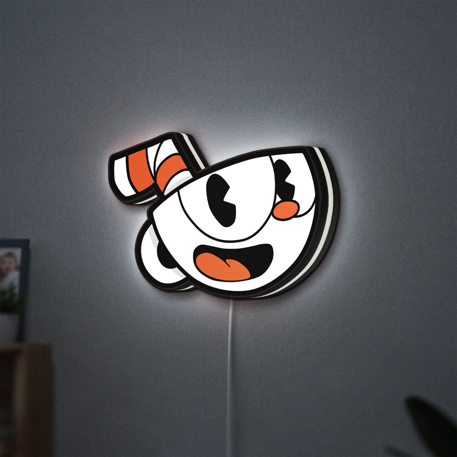 Cuphead LED lightbox hanging on a wall with white glow