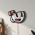 Unlit Cuphead LED lightbox mounted on a wall in daylight