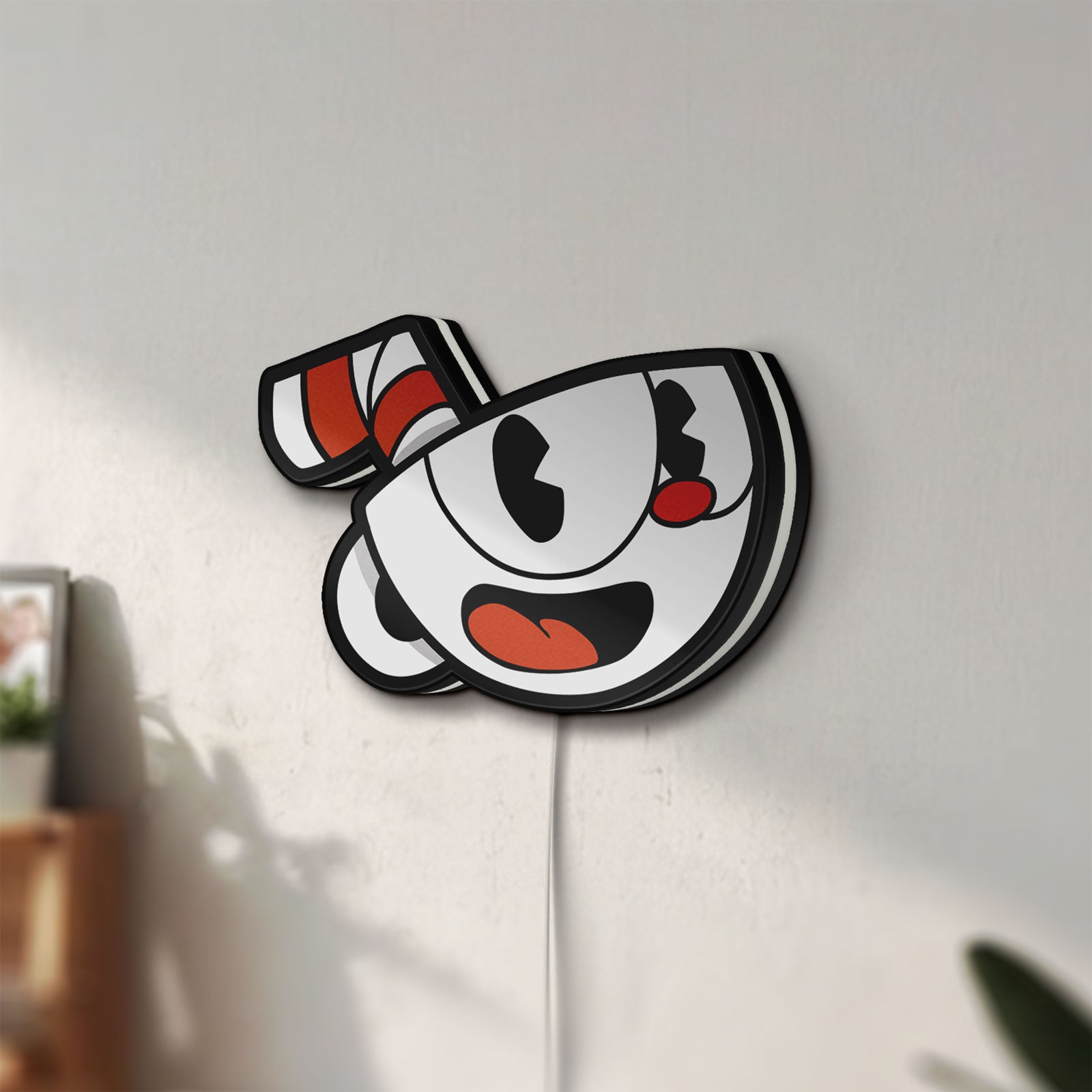 Unlit Cuphead LED lightbox mounted on a wall in daylight